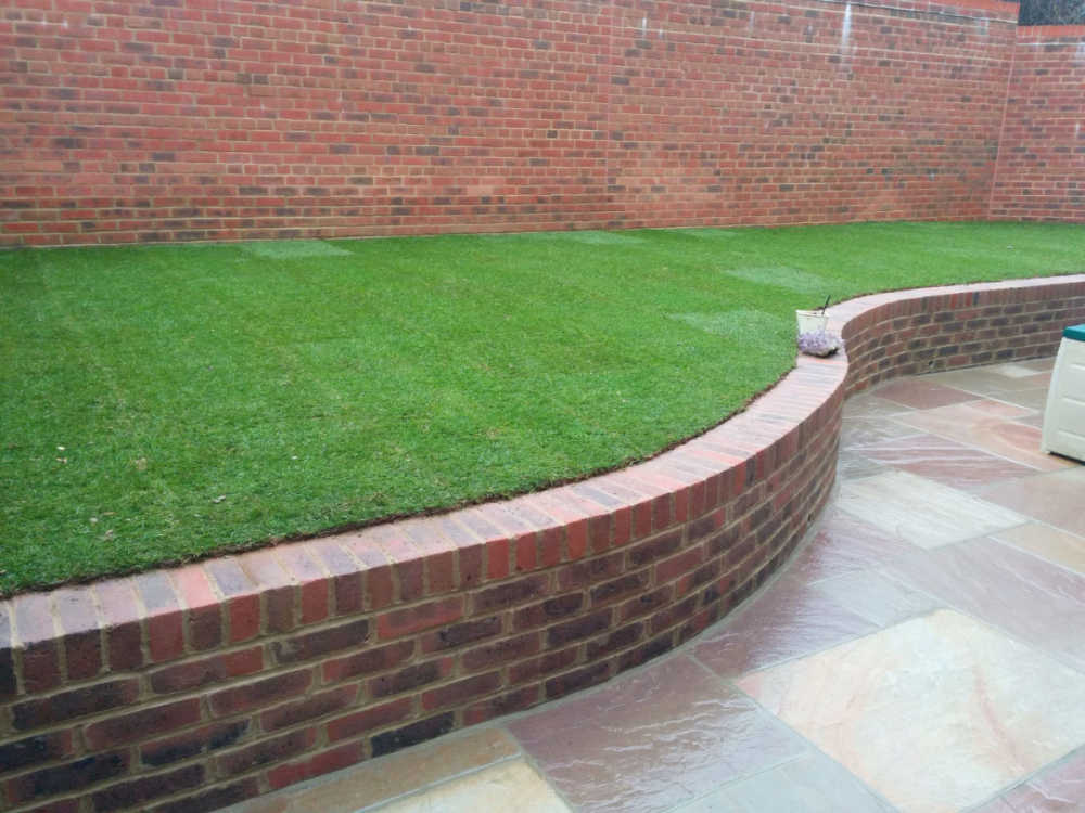 Arch - Curved bickwall cw artificial grass and indian sandstone patio